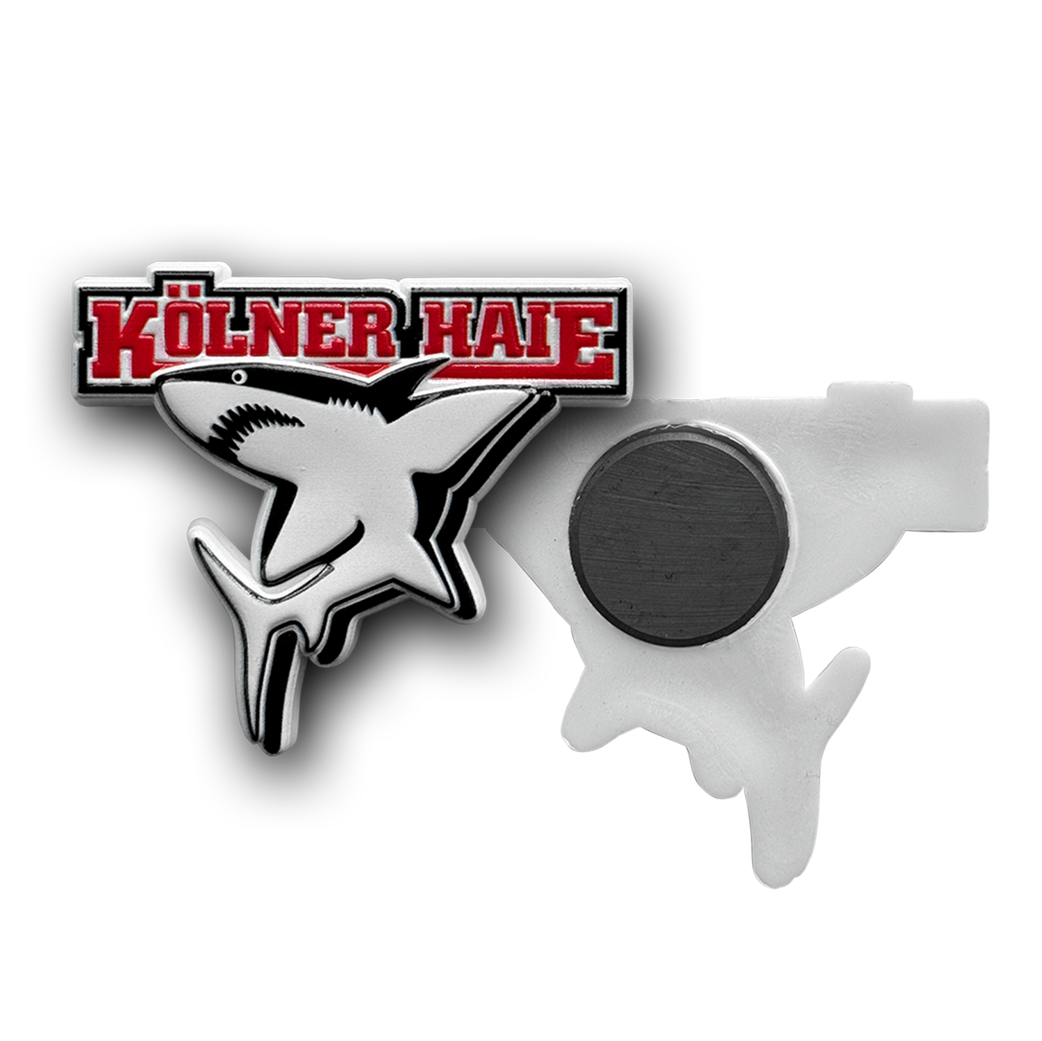Magnet BASIC Magnet in Form des Kölner Haie-Logos. Der vordere Teil zeigt einen stilisierten weißen Hai unter dem roten Schriftzug ‚Kölner Haie‘ in Großbuchstaben. Auf der Rückseite befindet sich ein runder Magnet zur Befestigung, angebracht an einer weißen Kunststoff
