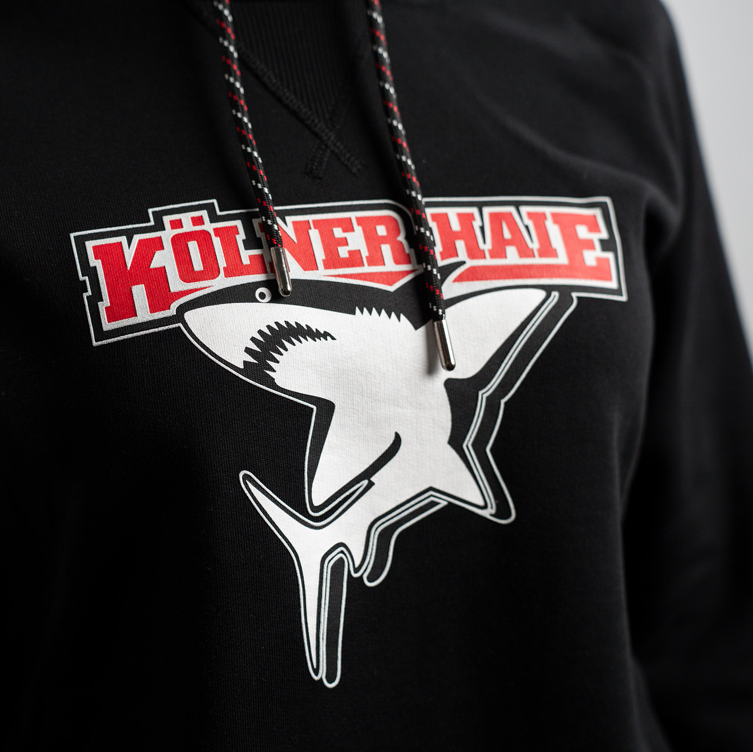 Detailansicht Kölner Haie-Logo auf schwarzem Damen Hoodie