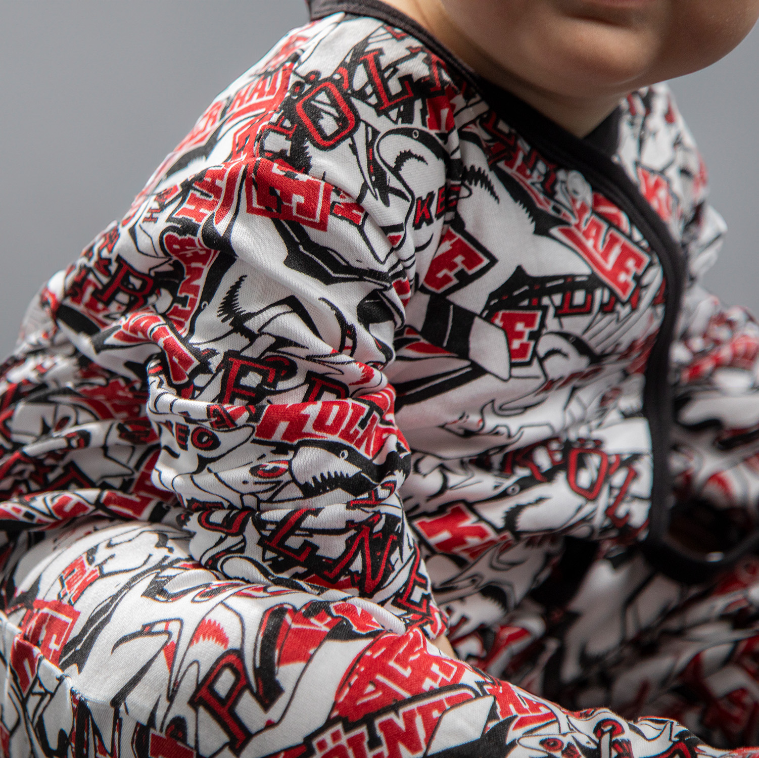 Detailansicht des Allover-Prints auf dem schwarz-weiß-roten Baby-Body von den Kölner Haien.